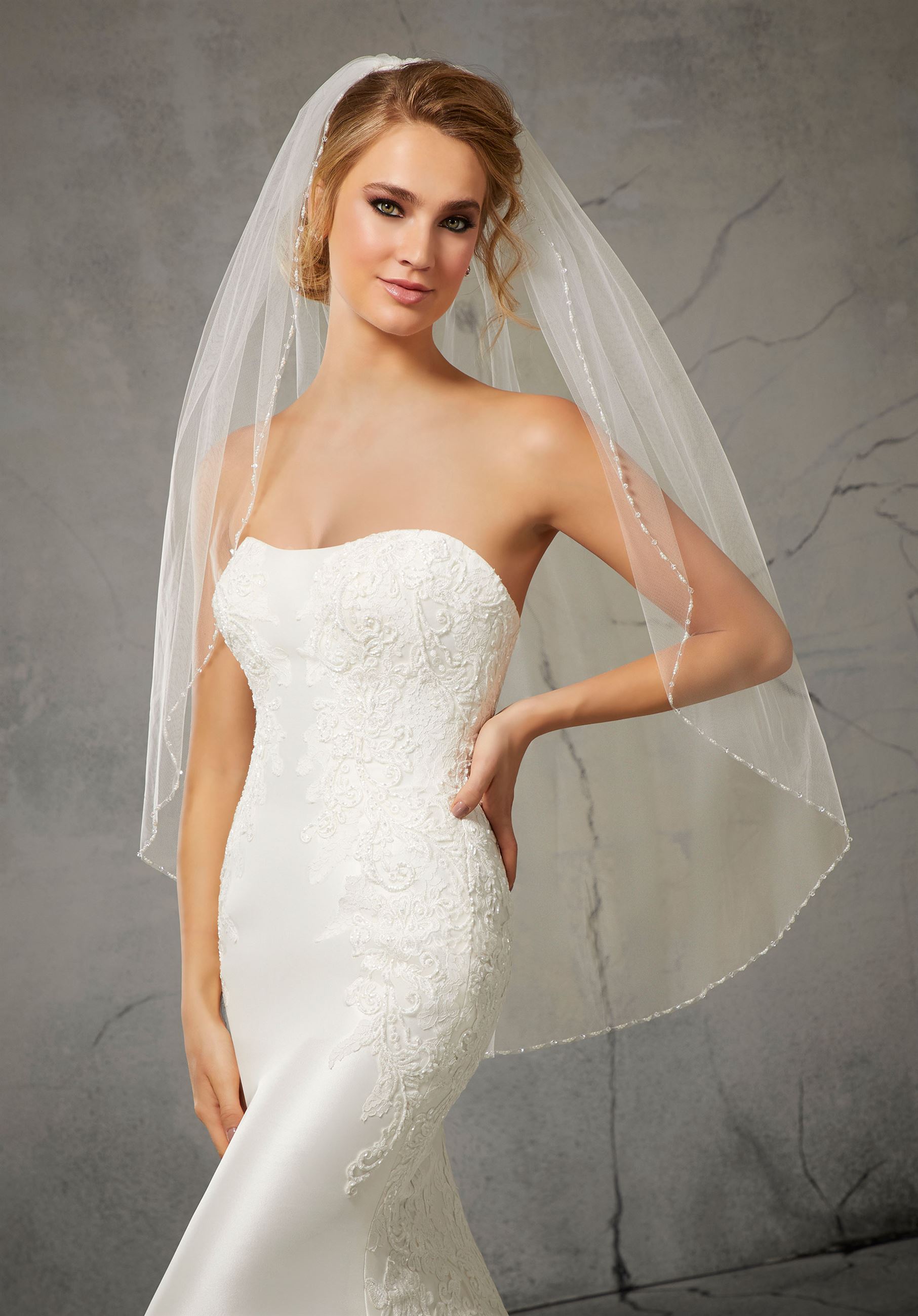Model wearing strapless wedding dress with beaded crystal veil