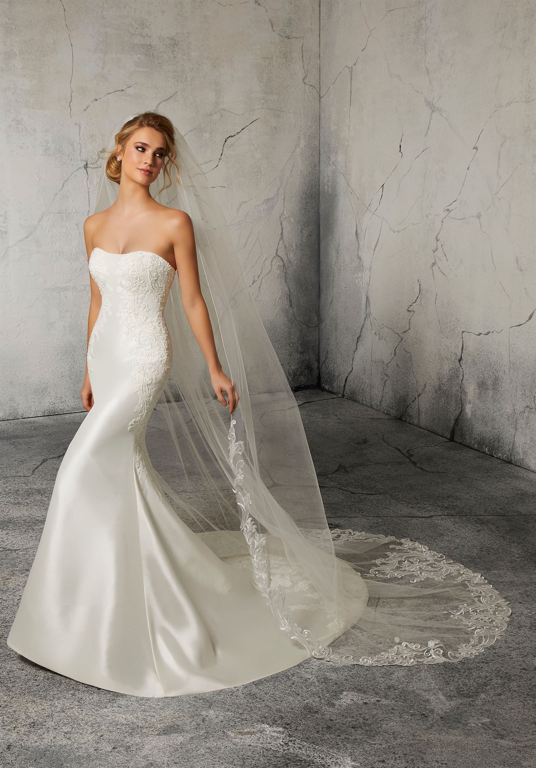 Model wearing strapless wedding gown with lace veil
